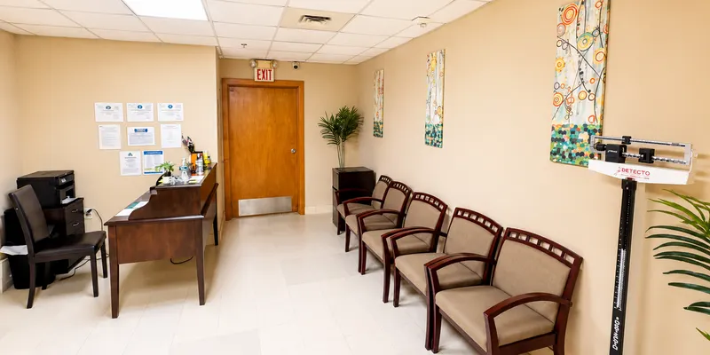 The clinic waiting area, with a front desk and a row of chairs.